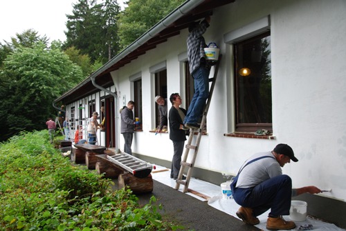 „Ehrenamtliche Handwerker“ mit Pinsel und Farbe bei der Arbeit