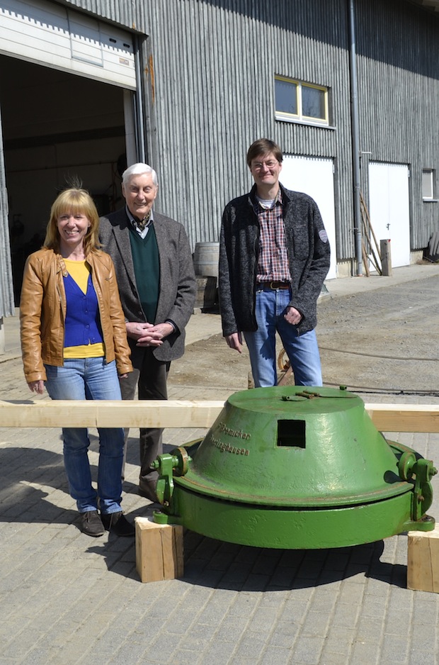 V.l.n.r.: Petra Dittmar (Volkskundlerin LVR-Freilichtmuseum Lindlar), Fiedrich Bremicker und Sven Bremicker mit dem gusseisernen Göpel der Firma Bremicker im Bauhof des LVR-Freilichtmuseums Lindlar (Foto: LVR-Freilichtmuseum Lindlar).