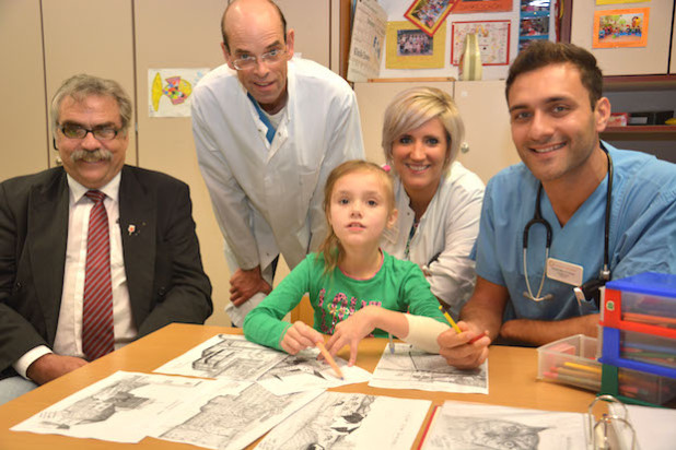 Das Bild zeigt (v.l.): Der Gummersbacher Sigfried Simons hat den Kinderärzten Dr. Markus Lorbacher, Charlotte Reich und Alwan Abdel Wahed einen dicken Ordner voller selbst gezeichneter Malvorlagen für kleine Patienten wie Chayenne geschenkt (Foto: Klinikum Oberberg GmbH).