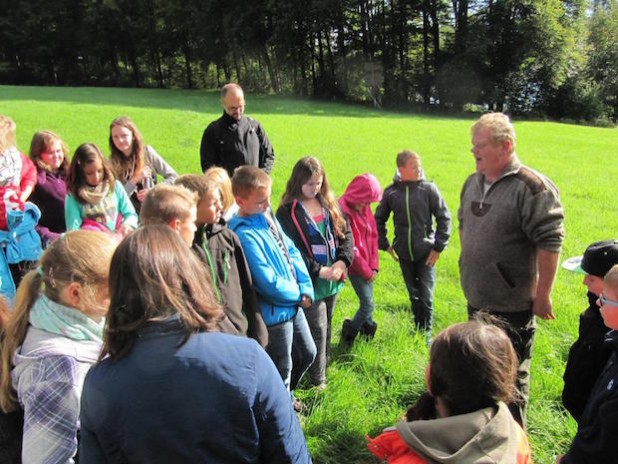 Herr Ommer erläutert auf einer Weide einen Wildschweinschaden - Foto: Gesamtschule Marienheide.